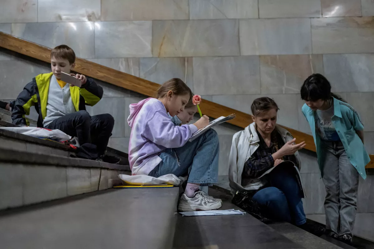Los estudiantes de la escuela asisten a una lección mientras se refugian dentro de una estación de metro durante una alerta de ataque aéreo, en medio del ataque de Rusia a Ucrania, en Kiev, Ucrania, el 3 de mayo de 2023.
