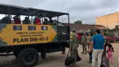 Un camión militar con letras que dicen Plan DN tres en donde militares ayudan a subir a tres adultos y una niña.jpg