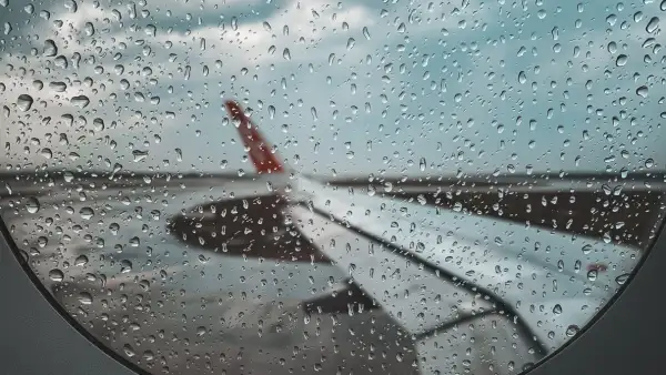 Vista del ala lateral de un avión desde dentro con la ventanilla con poca visibilidad tras el paso de lluvia.