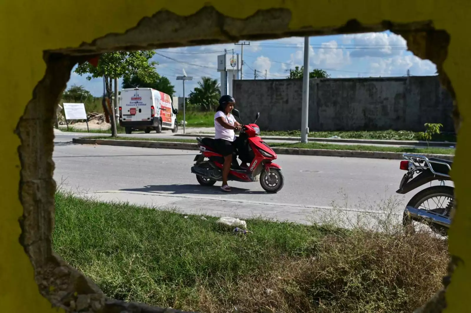 Una mujer pasa frente a una vivienda que comienza a ser demolida en Candelaria, Campeche, por estar cerca del derecho de vía del Tren Maya