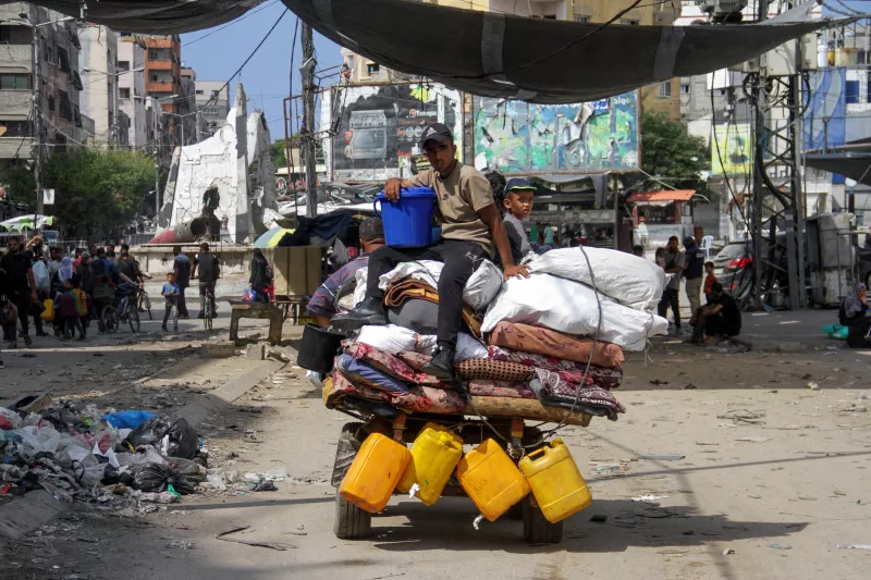 Los palestinos desplazados viajan en un carro tirado por animales mientras huyen de áreas en el norte de la Franja de Gaza, siguiendo una orden de evacuación israelí, en medio del conflicto entre Israel y Hamas, en Gaza el 6 de octubre de 2024.