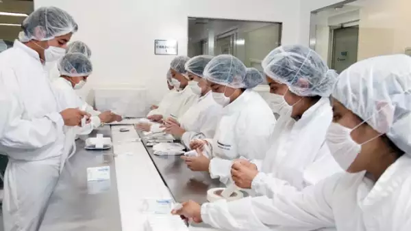 En esta área un operador revisa las cajas que ya salen armadas; otro coloca las etiquetas de seguridad; uno más las acomoda para que les imprima el lote y la fecha de caducidad.