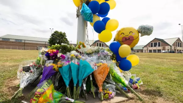 Un monumento de flores y globos crece frente a la escuela secundaria Apalachee el 5 de septiembre de 2024 en Winder, Georgia. Dos estudiantes y dos profesores fueron asesinados a tiros en la escuela el 4 de septiembre, y un sospechoso de 14 años, estudiante de la escuela, está detenido.