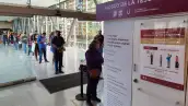 Personas formadas en una fila de un kiosco de la Tesorería de la CDMX. 
