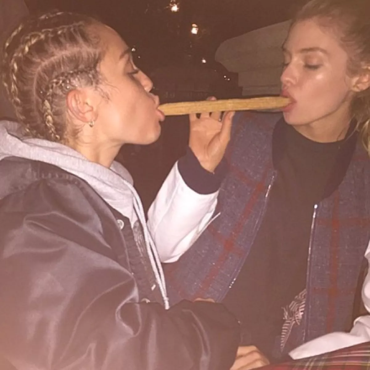 Miley y Stella compartiendo un churro en Disney.