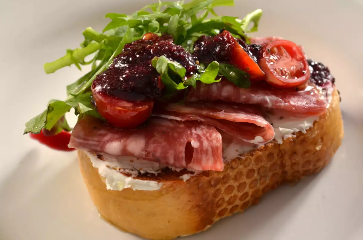 Pintxo de salami con queso crema y salsa de frutos rojos al chipotle de Mola