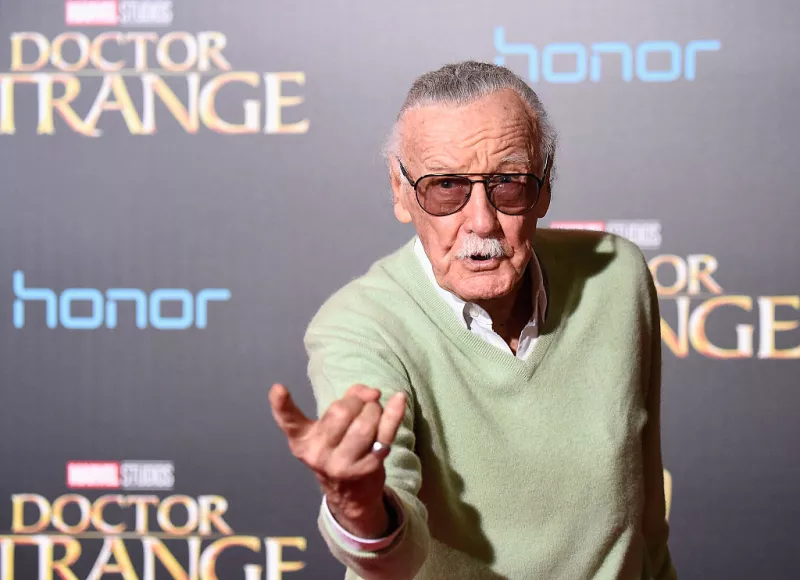 Foto de Stan Lee en octubre de 2016 con lenes oscuros y la mano derecha con el gesto de Spider-Man lanzando su telaraña.