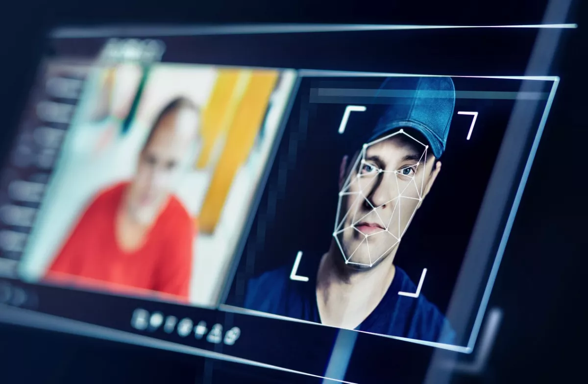 Pantalla de monitor de computadora que muestra el rostro de una persona con vectores de IA para generar una deepfake.