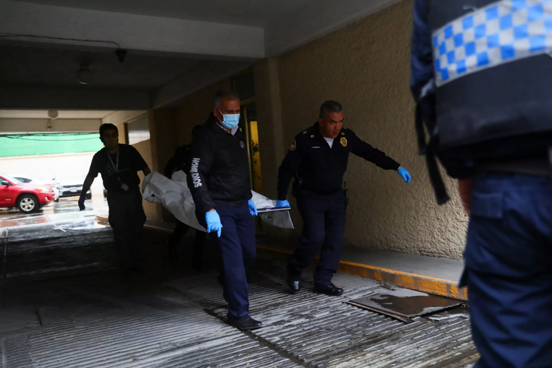 (Oficiales de policía cargan un cuerpo dentro de un edificio donde murieron tres personas, según medios locales en la calle Durango, colonia Roma en Ciudad de México)