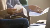 Personas revisan documentos y recibos relacionados con sus deudas y compromisos financieros.