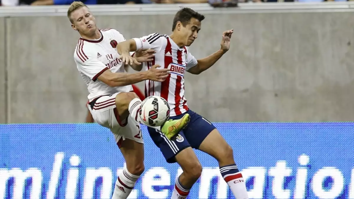 El defensor de Chivas Gerardo Rodríguez disputa un balón con el defensa del AC Milán, Ignazio Abate