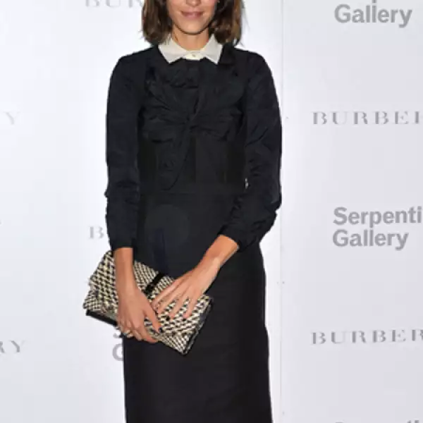 Alexa Chung combina un clutch con un atuendo sobrio.