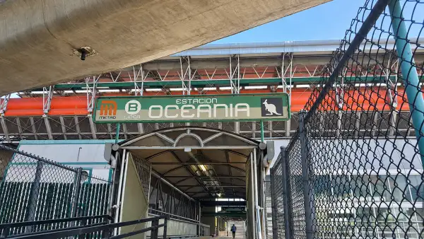 Entrada de la estación Oceanía del Metro de la Ciudad de México, con el letrero de acceso visible y la estructura elevada al fondo.