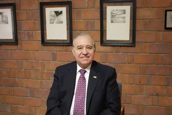 Valentín Díez Morodo sentado frente a una pared de ladrillo, vestido con traje oscuro y corbata.