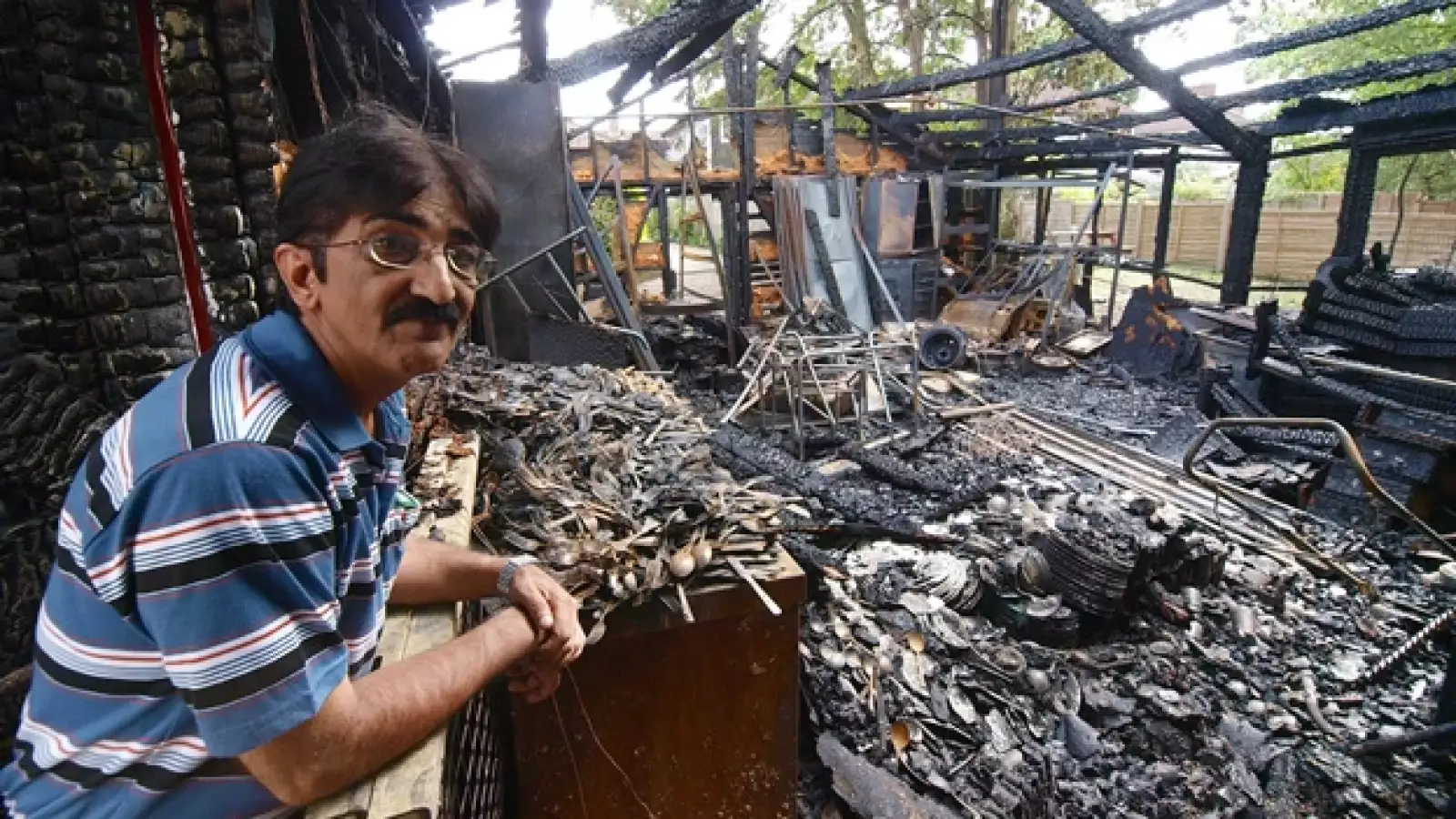 Azim Mohamed observa los restos de su negocio quemado