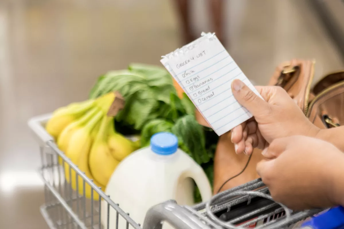 Unrecognizable woman checks items off grocery list