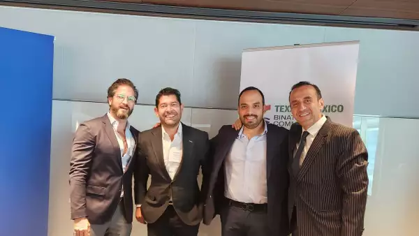 Cuatro hombres vestidos con traje, de pie, mirando a la cámara.