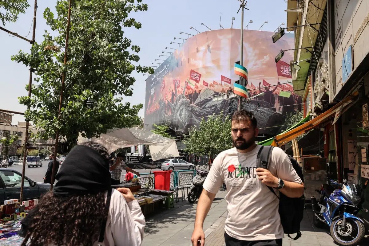 Los iraníes pasan junto a una valla publicitaria antiestadounidense en la plaza Enghelab, en el centro de Teherán, el 3 de agosto de 2026. Irán negó que se estuvieran llevando a cabo negociaciones con los Estados Unidos después de que el presidente de los Estados Unidos dijera que las nuevas conversaciones comenzarían el 3 de agosto en un esfuerzo por poner fin a su guerra, ahora en su sexto mes.