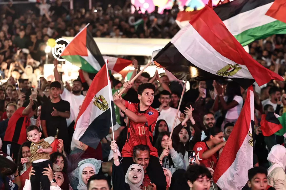 Los aficionados al fútbol palestino reaccionan mientras ven el partido de octavos de final de la Copa Mundial de la FIFA 2026 entre Argentina y Egipto en una pantalla en la ciudad de Ramallah, ocupada por Israel, Cisjordania, el 7 de julio de 2026.