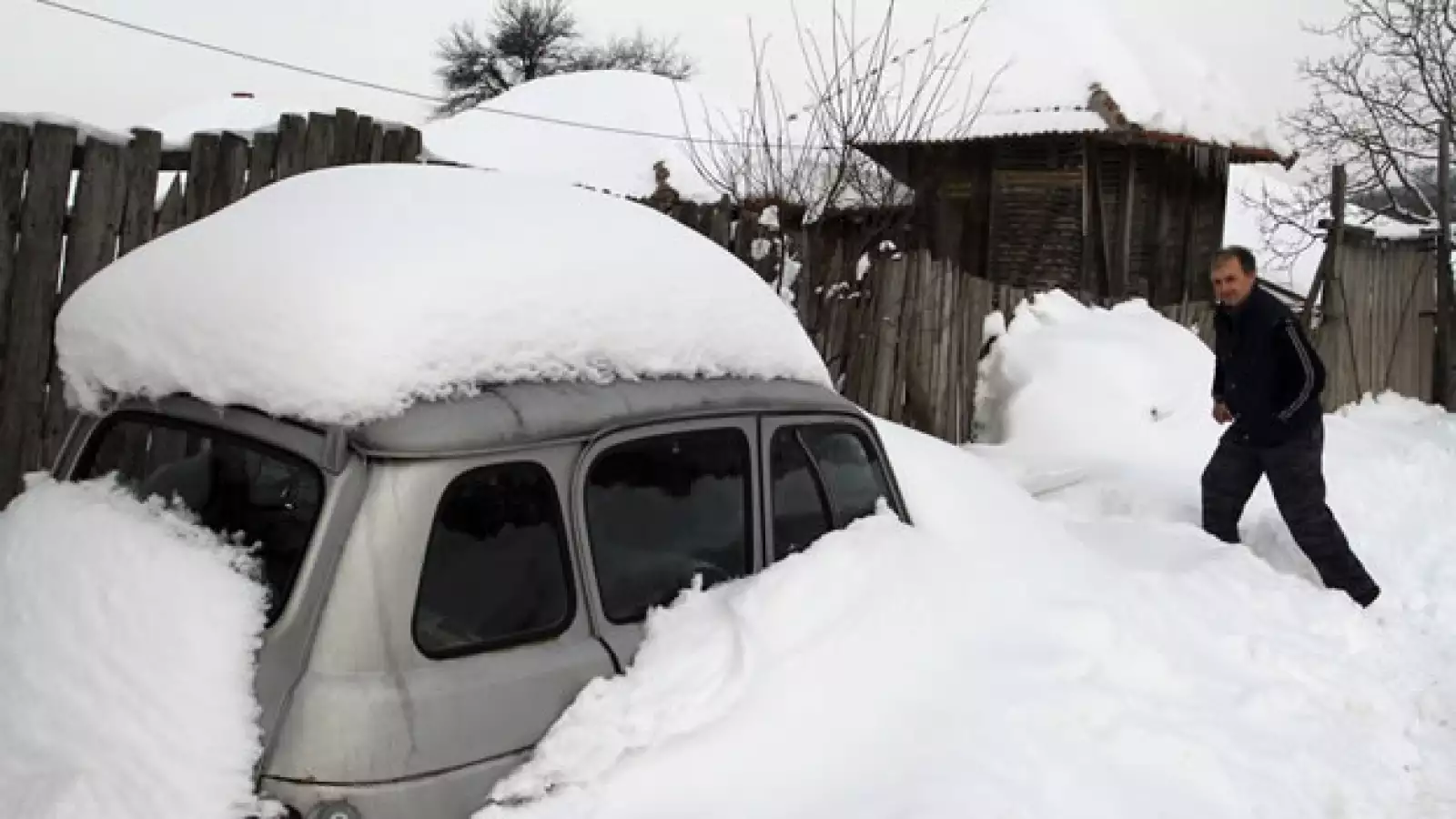 un hombre camina por una calle cubierta de nieve en serbia