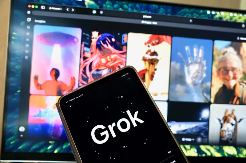 La aplicación Grok en un teléfono móvil frente a una pantalla con imágenes generadas por IA