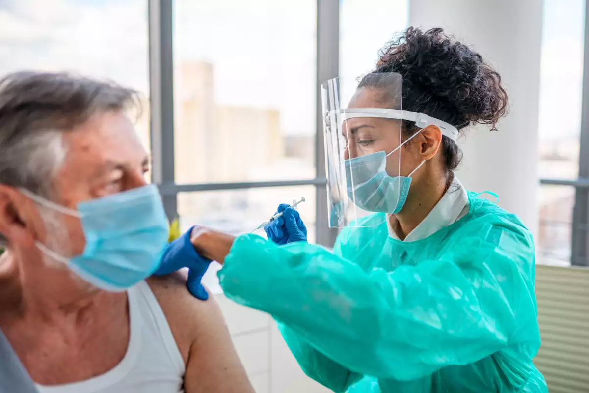 enfermera aplicando vacuna a adulto
