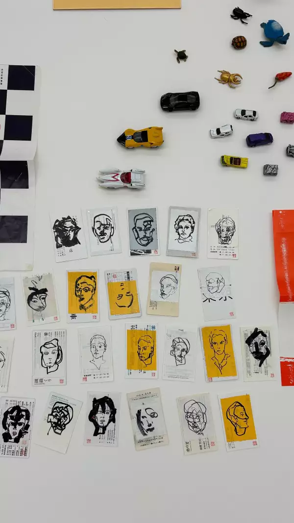 Foto de la obra "Working Table" de Gabriel Orozco que muesra distintas estampas y carritos miniatura ordenados.