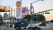 Una gasolinera Shell de Estados Unidos que muestra los precios del diésel mientras entra un tractocamión de color azul.