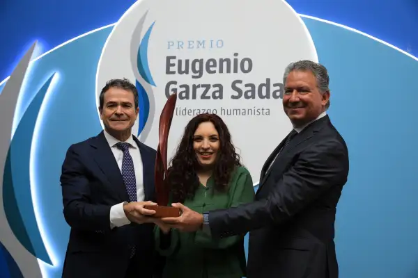 Dos hombres y una mujer sostienen una escultura que es parte de su premio.jpeg