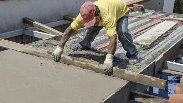Worker levels a floor cement mortar.