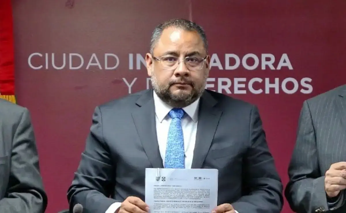 Omar Reyes Colmenares, titular de la Unidad de Inteligencia Financiera, sostiene un documento con ambas manos. 