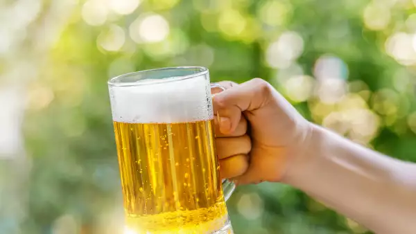 Man holds a glass of beer.