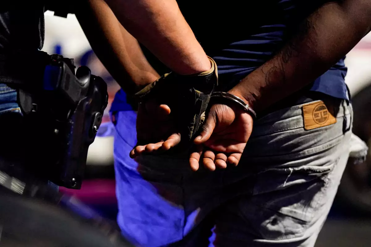 Un agente de las Investigaciones de Seguridad Nacional (HSI) del Servicio de Inmigración y Aduanas de los Estados Unidos detiene a un hombre detenido durante una parada de tráfico, después de que el presidente de los Estados Unidos, Donald Trump, desplegara la Guardia Nacional y ordenara una mayor presencia de las fuerzas del orden federales para ayudar en la prevención del crimen, en Washington, D.C., EE. UU., 17 de agosto de 2025.