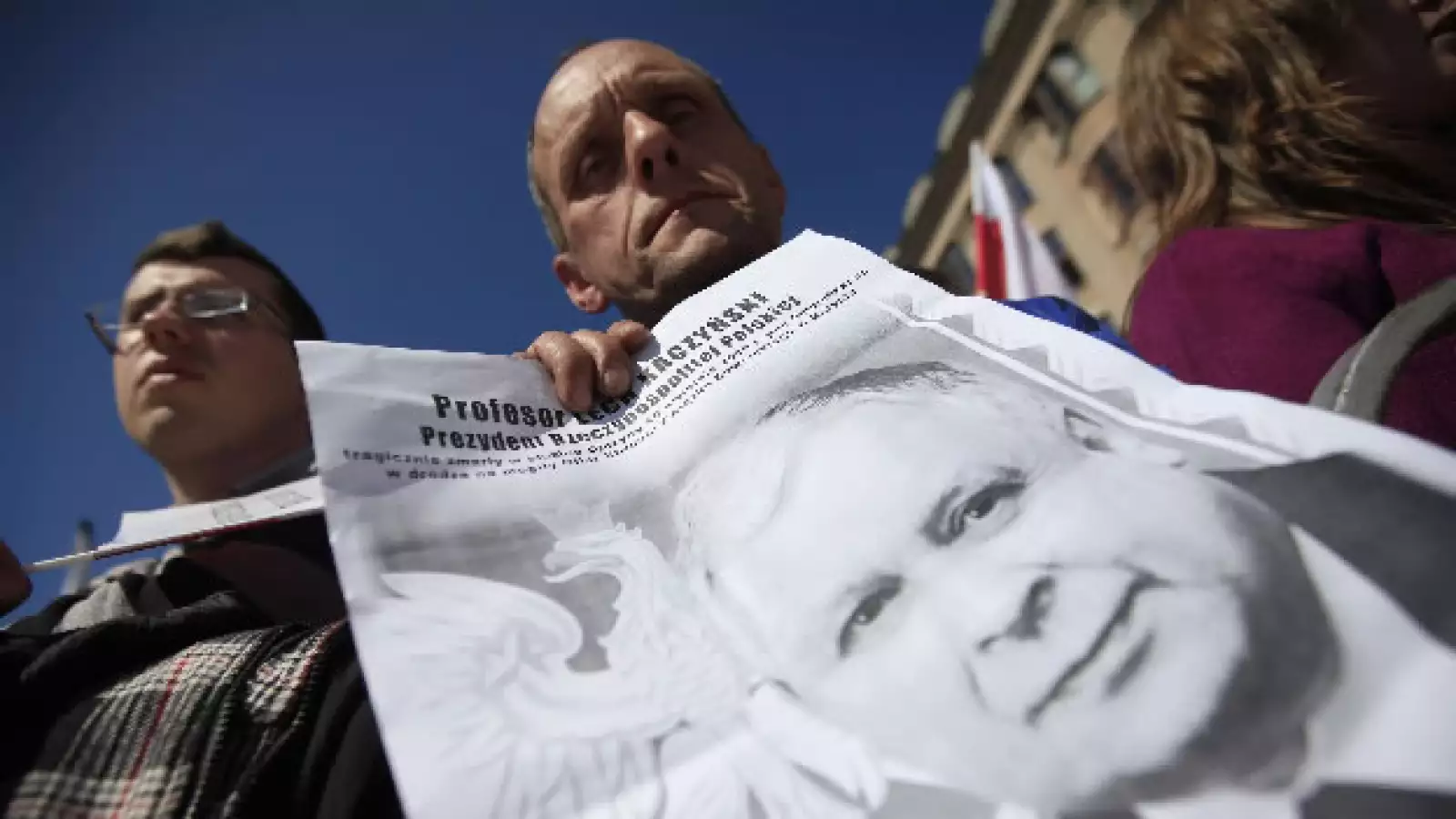 Un hombre sostiene un poster