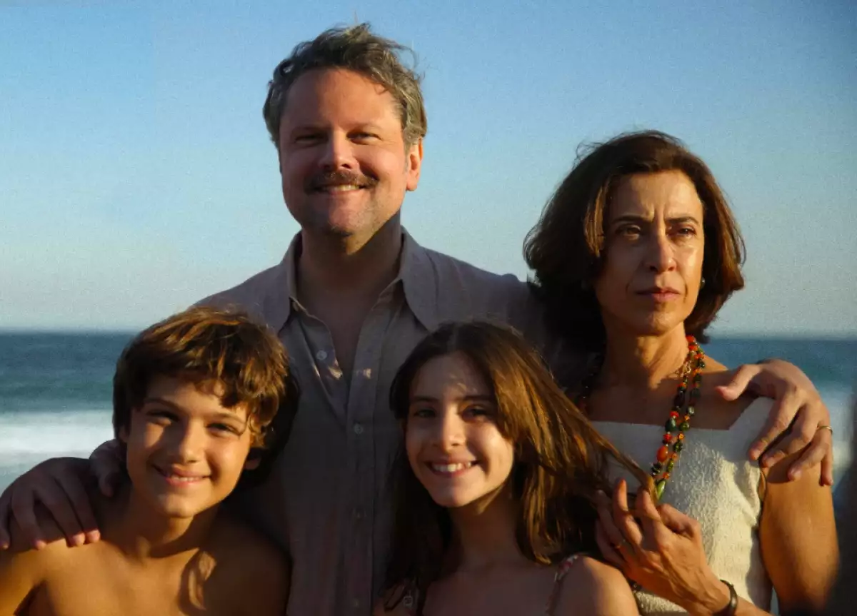 Foto de una escena de la película 'Aún estoy aquí' de la familia Paiva con ambos padres y dos de los hijos frente al mar.