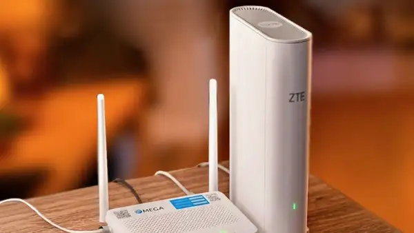 Dos moden uno con la marca de Megacable y otro de ZTE colocados en una mesa de madera color café.