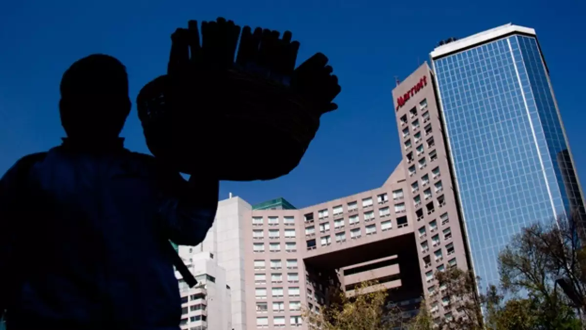 vendedor ambulante ante edificio lujoso