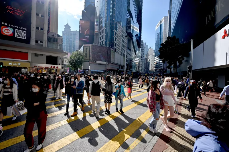 Peatones cruzan en una intersección en Causeway Bay en Hong Kong el 4 de enero de 2022. 
