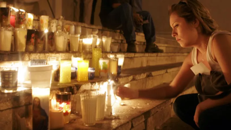 Una mujer coloca ofrendas en un altar