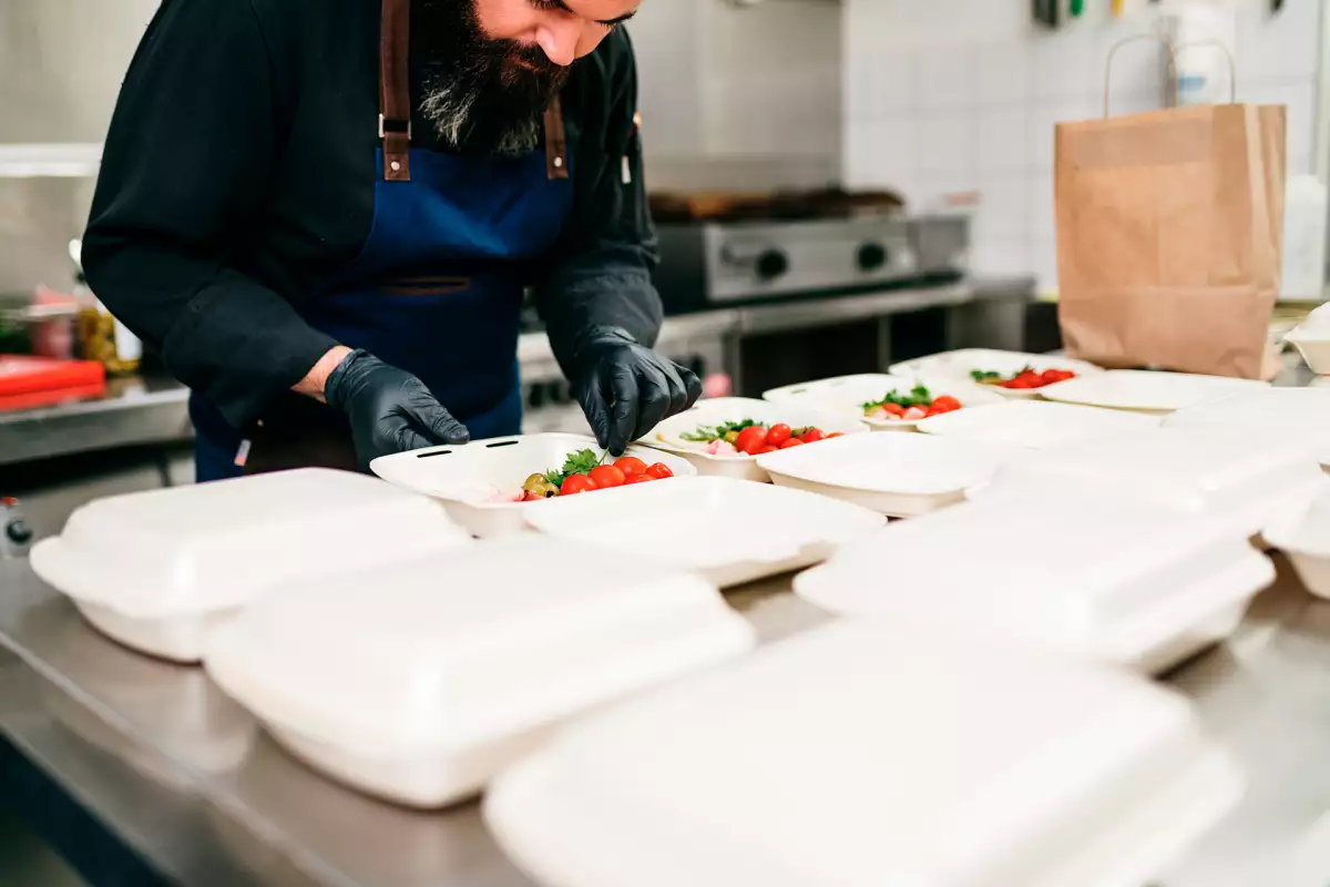 Un chef empaqueta diferentes comidas para Rappi, empresa de delivery patrocinadora del Premio al Mérito Restaurantero 2024