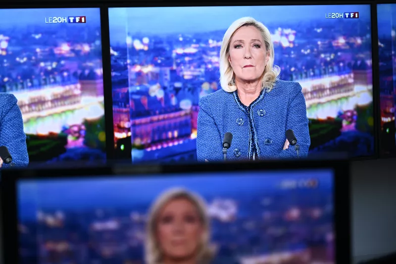 La presidenta del grupo parlamentario de extrema derecha Rassemblement National (RN), Marine Le Pen, es vista en los monitores durante una entrevista televisada emitida en el noticiario de la noche del canal de televisión francés TF1, en París, el 31 de marzo de 2025.