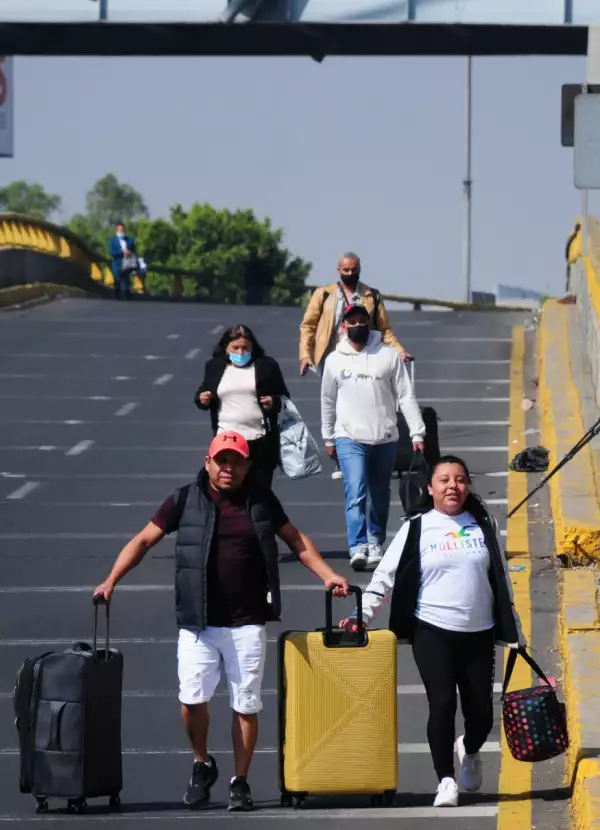 Usuarios del AICM caminan por la avenida para llegar al aeropuerto.
