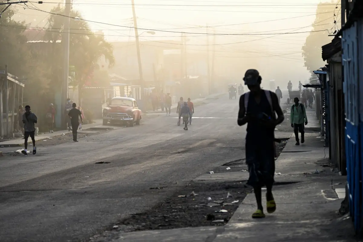 La gente camina por una calle en el barrio de La Guinera en La Habana el 13 de marzo de 2026. El presidente de Cuba, Miguel Díaz-Canel, confirmó el 13 de marzo de 2026 que funcionarios cubanos han mantenido recientemente conversaciones con representantes de los Estados Unidos, en medio de las mayores tensiones entre Washington y La Habana