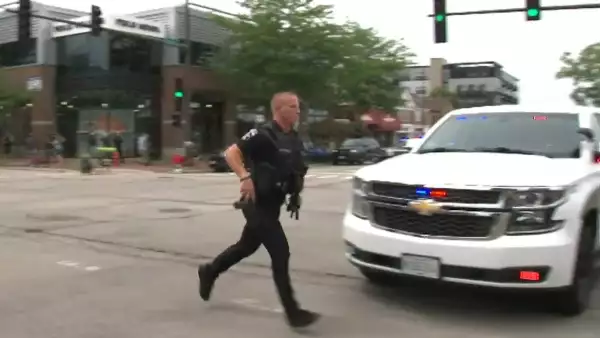 Un oficial de policía cruza una calle después de que estallaran disparos en una ruta del desfile del 4 de julio en el rico suburbio de Highland Park, Illinois, EE. UU.