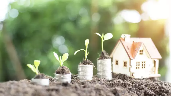 Property investment and house financial concept, coin stack with wooden house