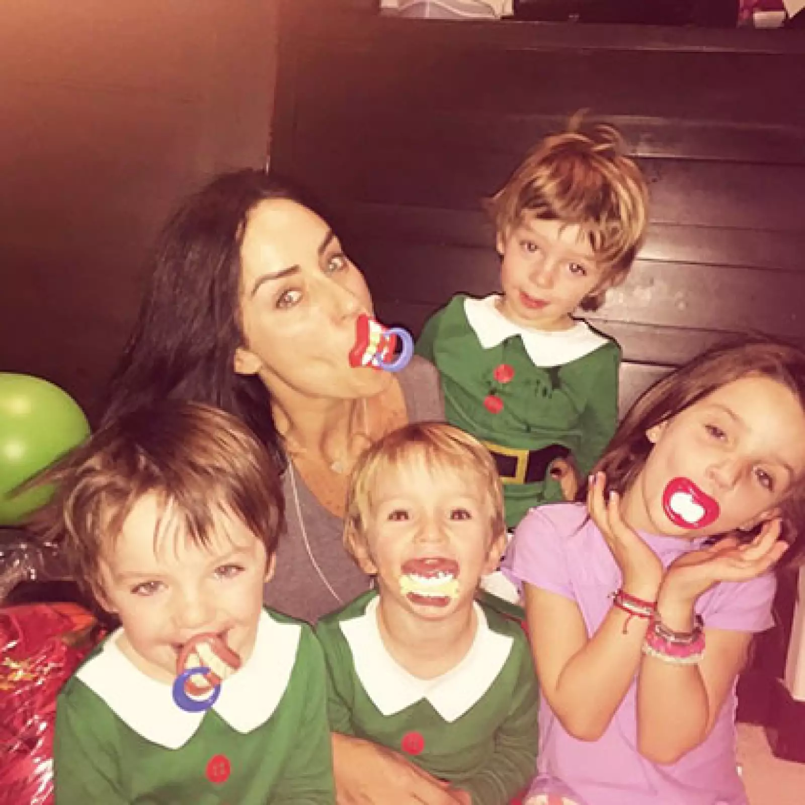 Como pequeños duendes de Santa Claus, así comparten cámara con su mamá y su hermanita.