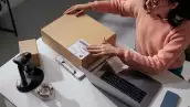 Person handling a box at a modern desk