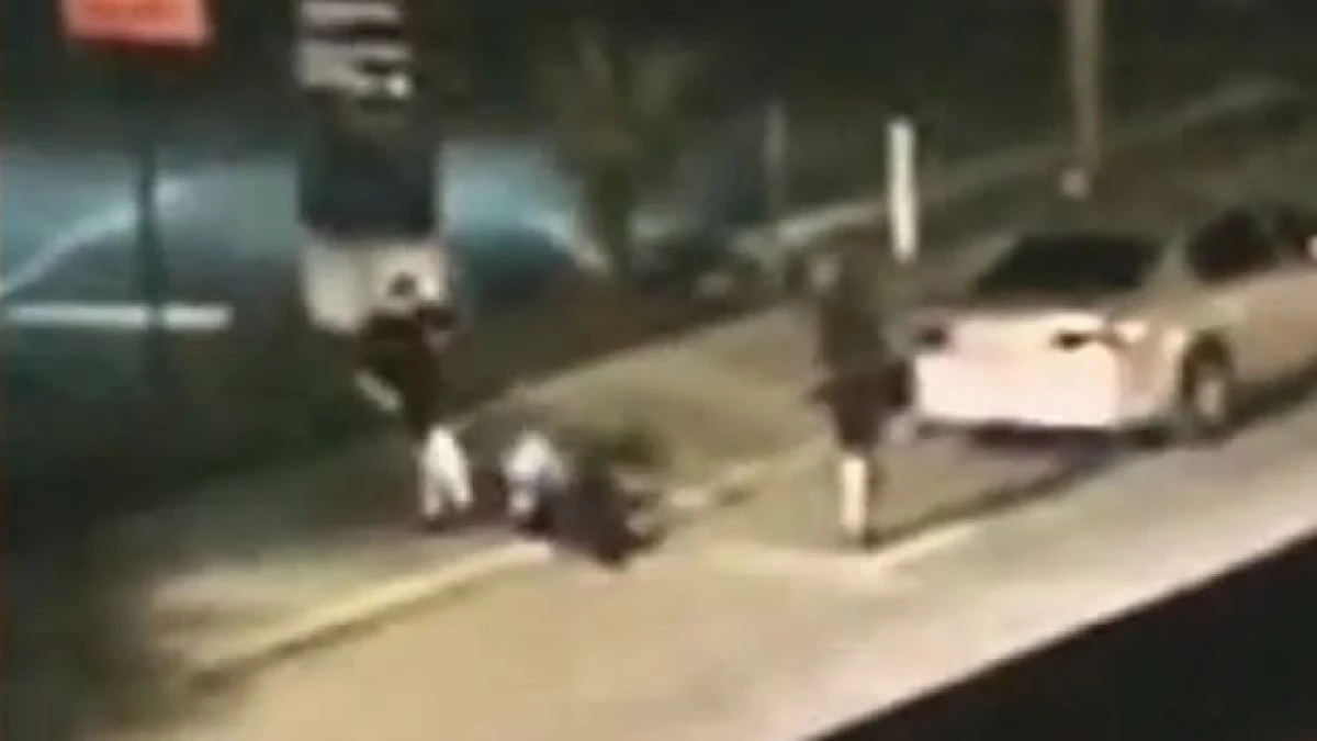 Un policía (izquierda) patea en la cabeza a Noel Carter, que está en el piso, mientras otro oficial observa en el centro de Orlando
