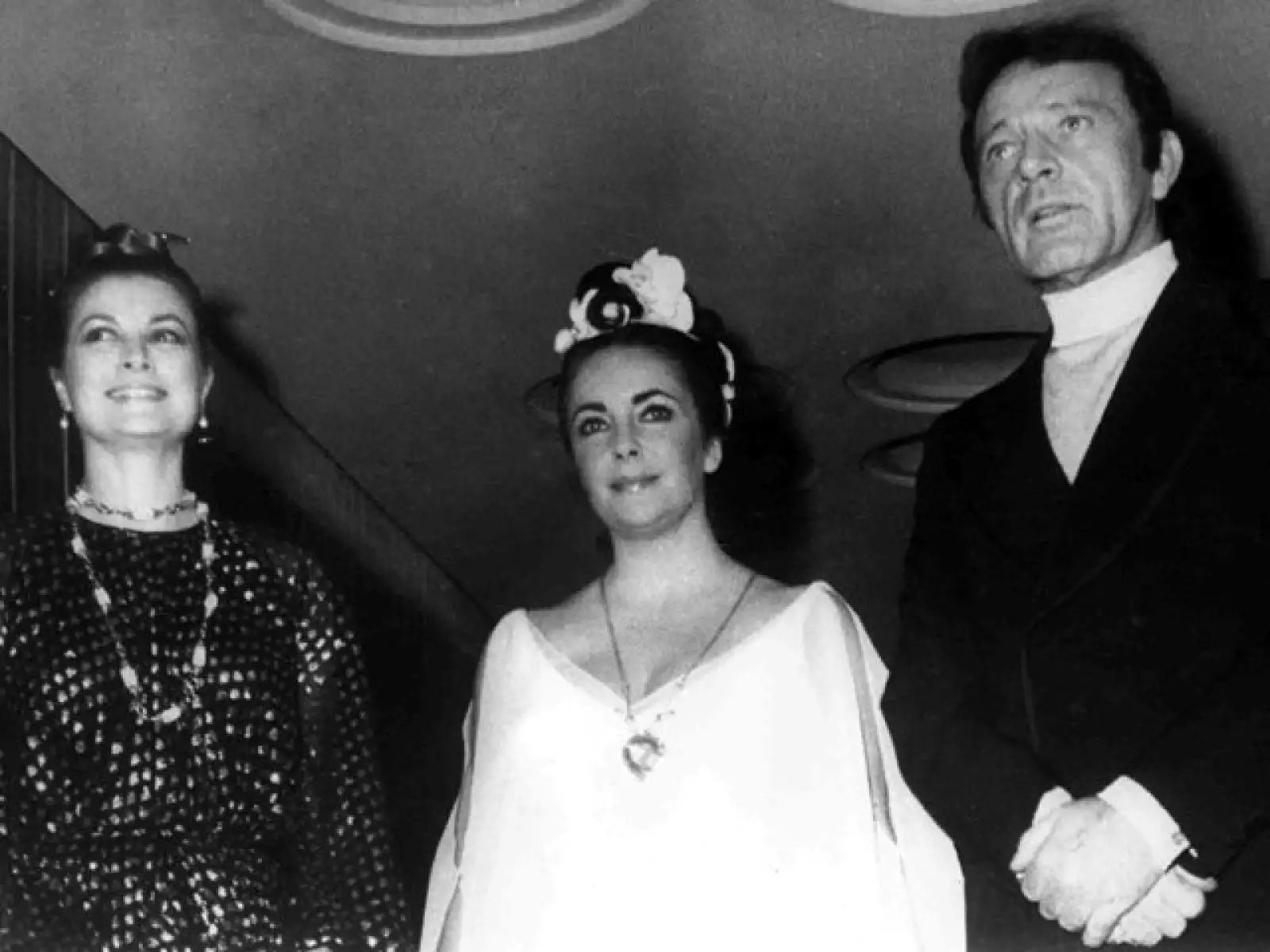 Grace al lado de Elizabeth Taylor y su esposo en la época, Richard Burton, en el Hotel Duna International, en Budapest, el 27 de febrero de 1972. Taylor festejaba sus 40 años.