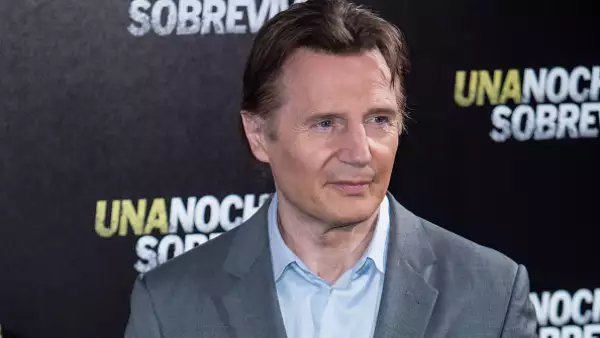 Foto del actor Liam Neeson con camisa azul claro y saco gris.